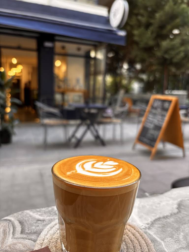 A freshly made latte with latte art outside TOOL Specialty Coffee in Bostanlı